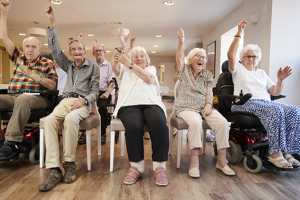 Group Of Seniors Enjoying Fitness Class In Retirement Home